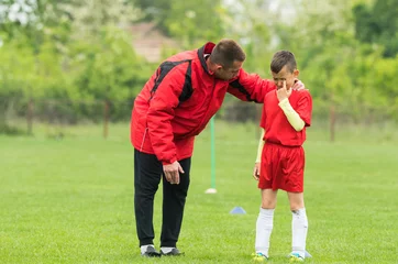 Foto op Plexiglas Kids soccer football - coach comfort little soccer player after a missed goal © Dusan Kostic