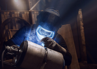 Welding of stainless steel pipes with argon, welding mask close-up - obrazy, fototapety, plakaty