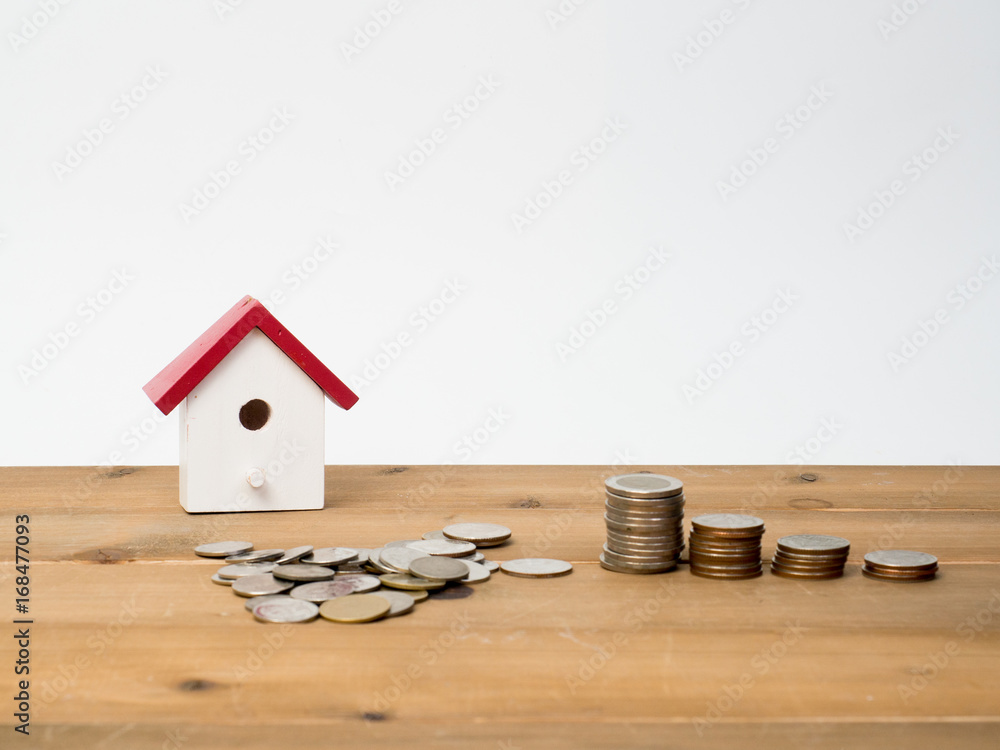 Wall mural Money coins stack growing with red house on wood background. Business growth investment and financial concept ideas.Real estate investment. House and coins on table.Save money with stack coin.