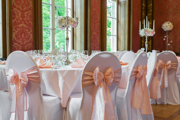 Decoration of the table in a pink style. Wedding decorations in pink tones. Glasses and plates on the layer