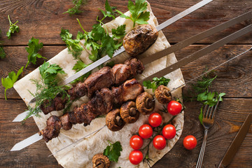 Shish-kebab with field mushrooms and cherry tomatoes on lavash. Barbecue, natural food preparing on fresh air, top view