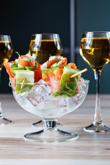 tapas in the form of rolls with salmon on ice and three glasses of Scotch