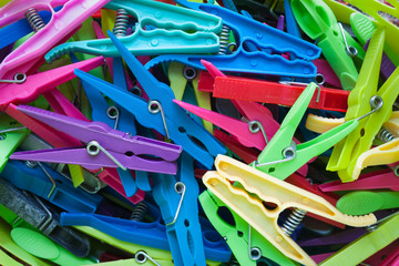 A jumble of various old coloured plastic clothes pegs
