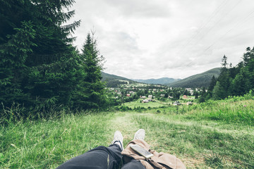 Fototapeta premium man lying on the ground and enjoying view of mountains