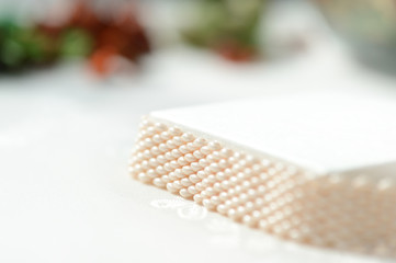 White beaded bracelet on a textile background close up