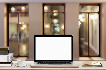Fototapeta premium Blank screen laptop, coffee cup, books and notebook on wood table with night view background.
