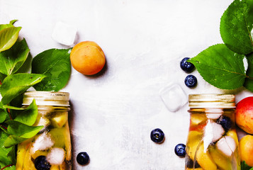 Two bottles with fruit tea with apricot, blueberry and ice, food background, top view