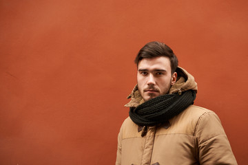 Waist up shot of attractive confident young European male with beard and mustache dressed in winter clothes, staring at camera with serious look. People, lifestyle, seasons and clothing concept