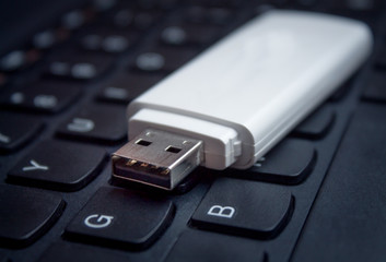 USB Flash drive on computer laptop keyboard.