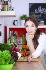 Young woman standing near desk in the kitchen
