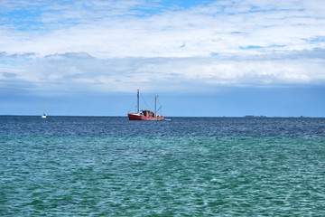 Very old and decayed wooden boat with masts and rigging floating at anchor © nielskliim