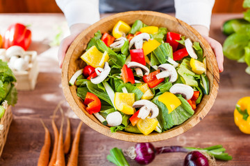 hands holding an healthy fresh vegetarian salad in a bowl