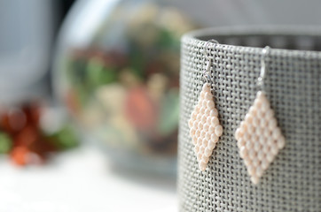 White beaded earrings on a gray background close up