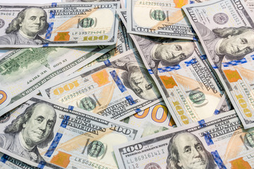 One hundred dollars banknotes on table as background.