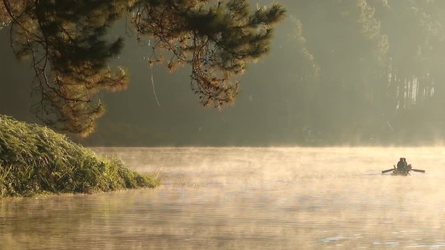 beautiful scenery - bamboo rafting through the mist on the lake in morning.