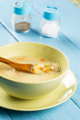 Green bowl filled with soup with vegetables and meat
