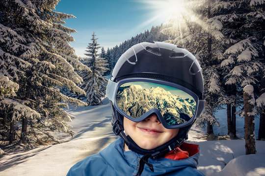Kind in Winterlandschaft mit Skibrille und Helm