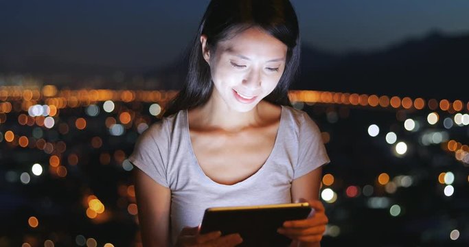 Woman looking at tablet computer in the evening