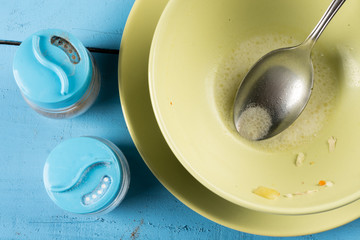 Flat lay above domestic soup bowl with metal spoon on the table with selective focus