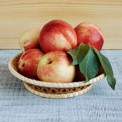 Ripe fresh nectarines in the wicker basket