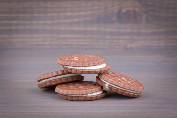 Biscuits with sweet filling on a wooden background.
