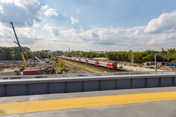 Passenger long-distance train rides under the bridge
