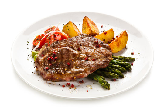 Grilled beef steaks,chips and asparagus on white background