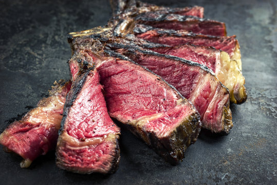 Barbecue dry aged Wagyu Tomahawk Steak sliced as close-up on old board