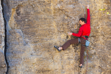 Naklejka na ściany i meble climber climbs the rock..