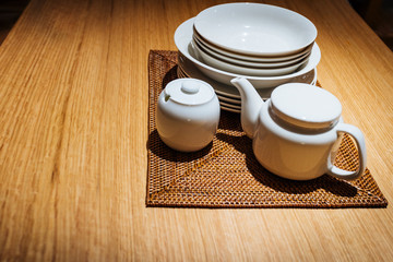 Fototapeta na wymiar Group of white dishes on wooden table.