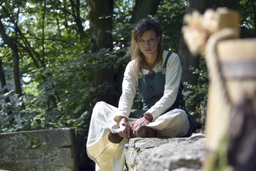 Nordic witch sitting on the castle wall watching the enemy