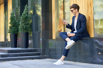 Trendy Young Man Relaxing with Smartphone