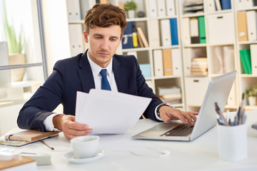 Modern Businessman Reading Documents in Office