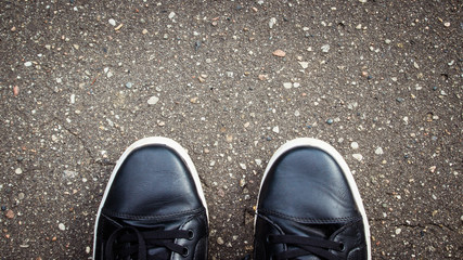 Black road asphalt texture pattern background. Shoes.