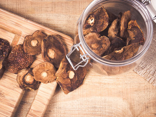 Dried forest mushrooms on a wooden table.