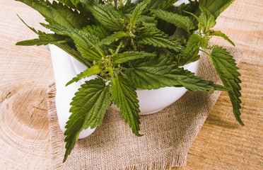 Fresh nettle on a wooden table. The source of vitamins. herbal medicine.
