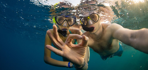 Young couple enjoying snorkeling underwater. Selfie portrait - obrazy, fototapety, plakaty