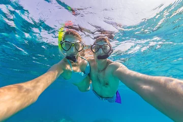 Poster Young couple enjoying snorkeling underwater. Selfie portrait © Jag_cz