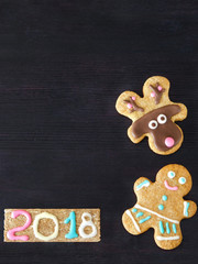 New Year and Christmas background. Funny gingerbread cookies are framing the dark background