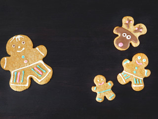 Dark Christmas background. Gingerbread men and deers are framing empty place for a text