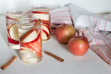 Soda water with apple on white wooden table