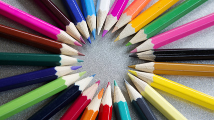 colored pencils in a circle on grey background