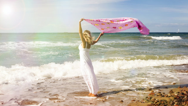 Woman Walking On Beach And Holding Shawl In The Wind