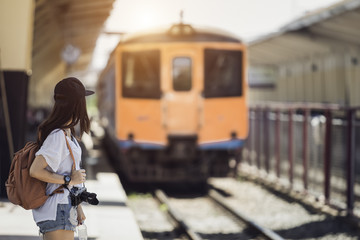Naklejka premium Traveler woman walking and waits train on railway platform