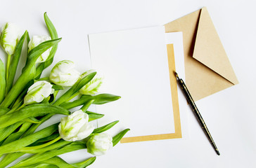 Letter, envelope and tulips on white background. Invitation card, or love letter. Top view, flat lay