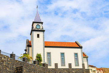 Church building against blue sky with white clouds on coast of Madeira island, Portugal