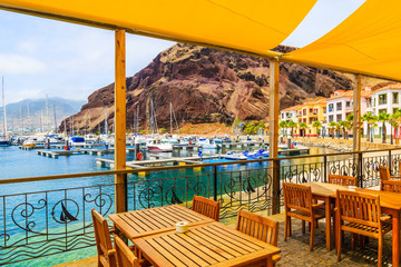 Fototapeta na wymiar Restaurant terrace in sailing port on coast of Madeira island, Portugal