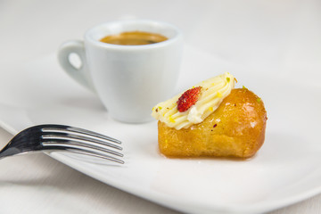 Neapolitan babà and coffee on white white dish