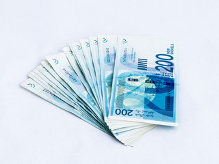 Several new banknotes worth 200 Israeli new shekels on a white  background