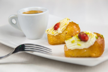 Neapolitan babà and coffee on white white dish